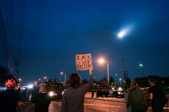 Image of a protestor holding a "Black Lives Matter" sign.