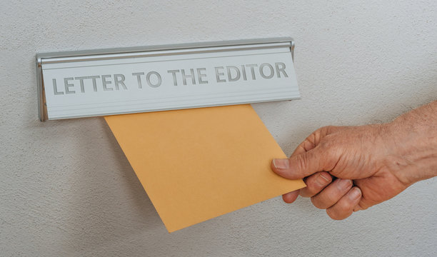 Image of someone submitting a letter to the editor drop-box.